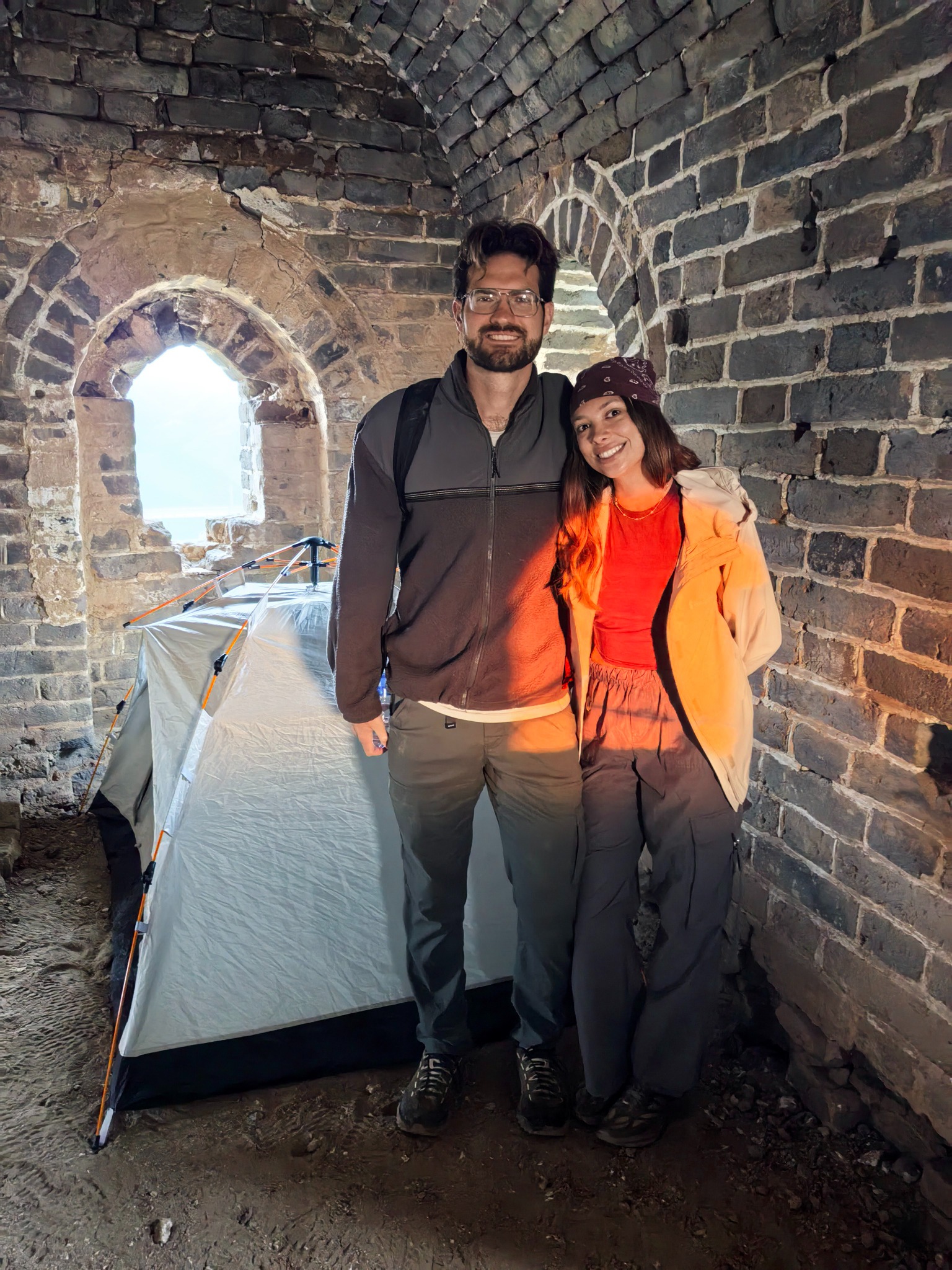 Two travelers beside a tent inside a Great Wall watchtower